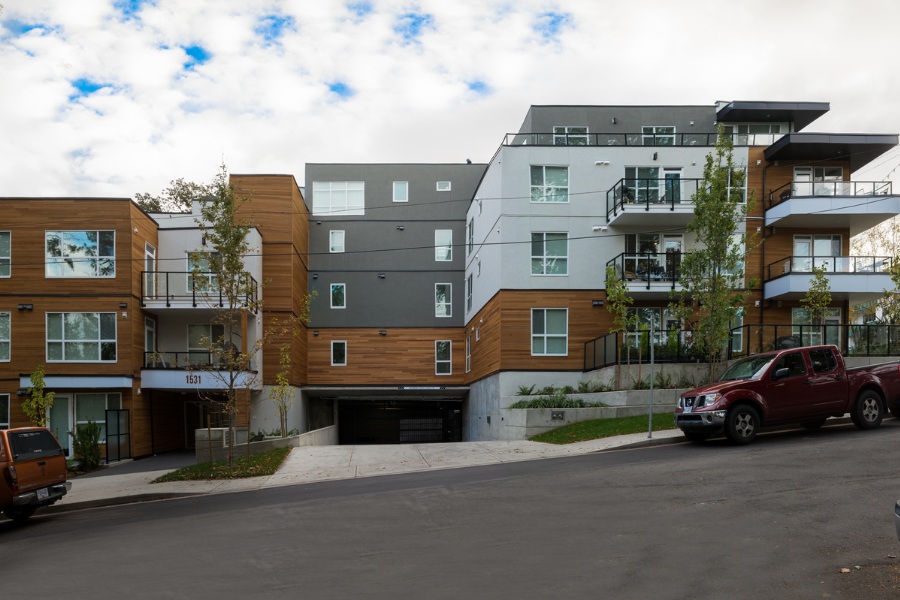 Elford and Pandora Condos, in modern white and grey siding with horizontal wood accents and patios.