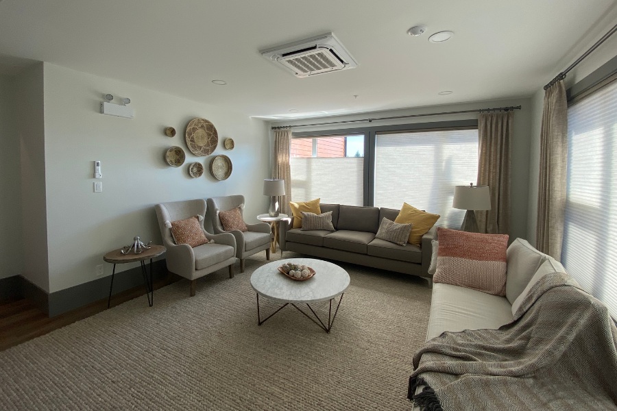 A living room with a large rug and large seating area, in the Qwalayu House, designed by Alan Lowe Architecture.