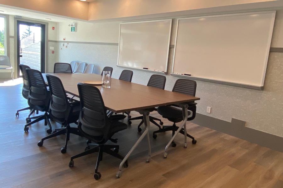 An office with a large table and seven office chairs in the Qwalayu House, designed by Alan Lowe Architecture.