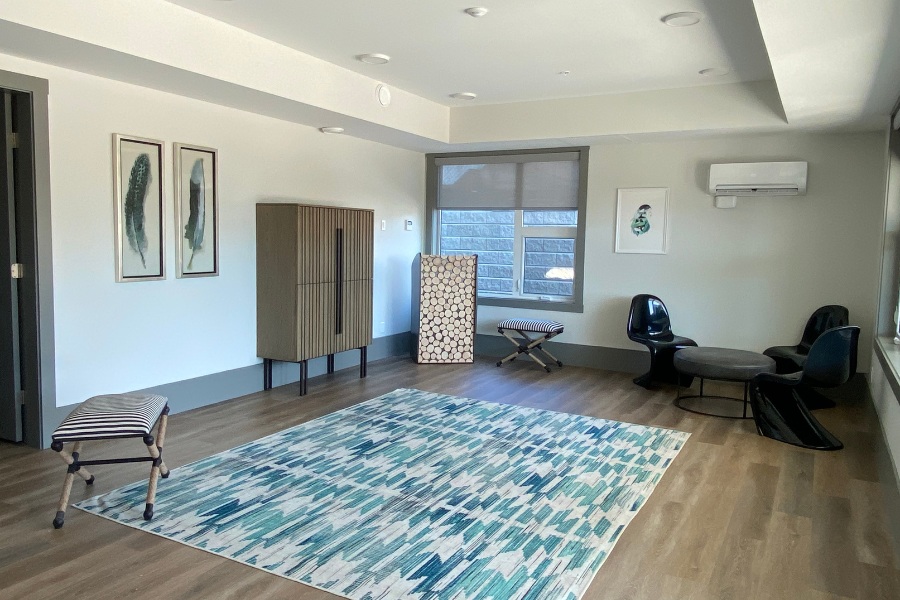 A room with a large rug and small seating area, in the Qwalayu House, designed by Alan Lowe Architecture.