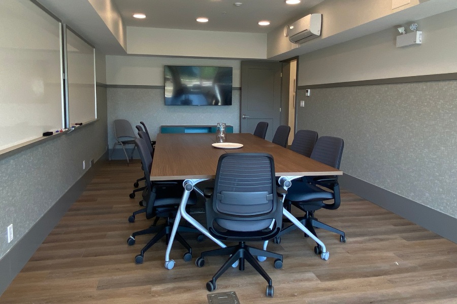 An office with a large table and seven office chairs in the Qwalayu House, designed by Alan Lowe Architecture.