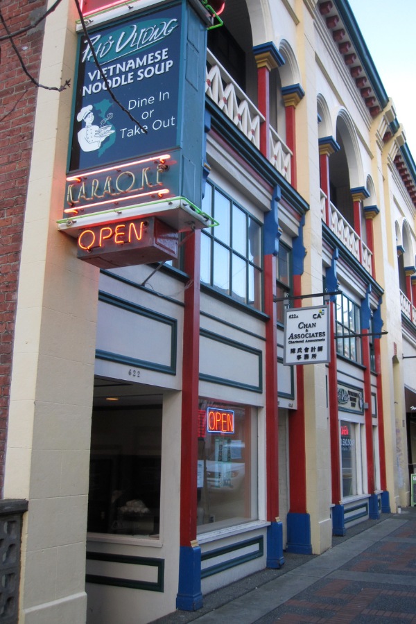 The exterior of a Gee Tuck Tong Building, a commercial property, designed by Alan Lowe Architecture, with blue, red and white  traditional siding.